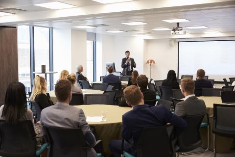 Large meeting observing a presentation